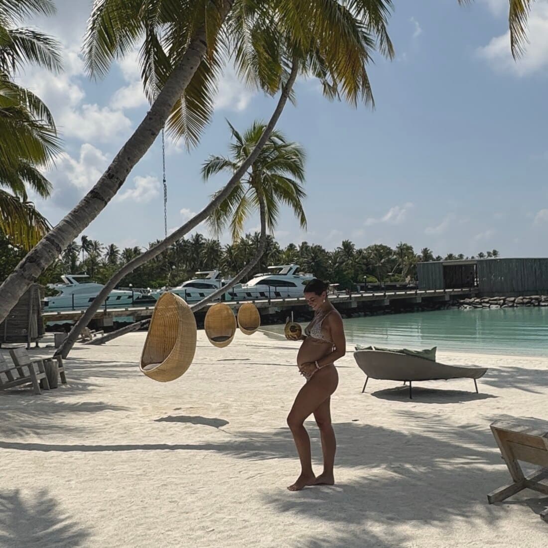 Anika steht in der Palmenallee am Strand, Schatten der Wedel im Sand