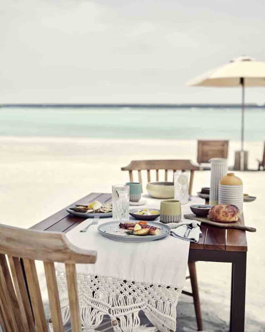 Gedeckte Tafel direkt am Strand, das Meer dahinter