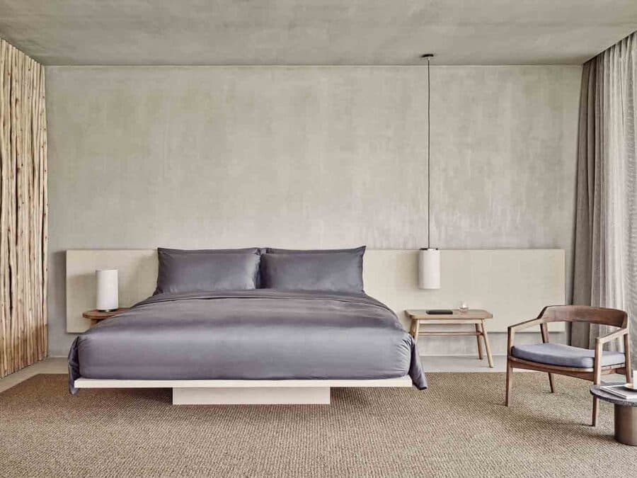 Das Fari Studio: Bett vor heller Wand, Vorhang zur Terrasse